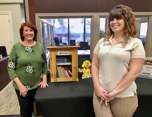 Kiwanians Charlene and Asst Branch Manager Dynah Ruppert with a book box at BayFirst Bank, Seminole.