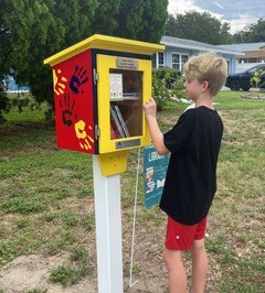 : A reader borrows a book from our neighborhood free library box.
