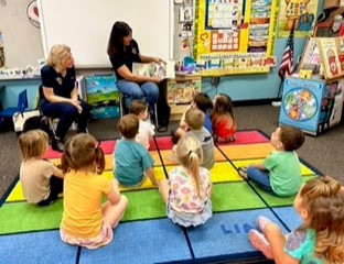 Sandra & Debbie reading to a classroom of preschoolers.