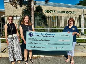 Club Treasurer Charlene Jasmin presenting a $1,000 donation to Dr. Christine Wilson, Principal of Orange Grove Elementary School.